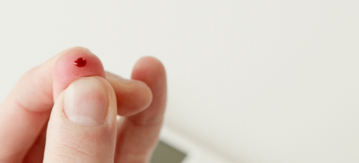 Imagem de uma pessoa usando um smartphone e medindo alimentos com um aplicativo de contagem de carboidratos.